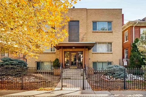 A brick house with a black gate in front.