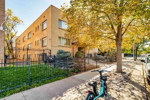 A bike is parked on a sidewalk in front of a brick building.