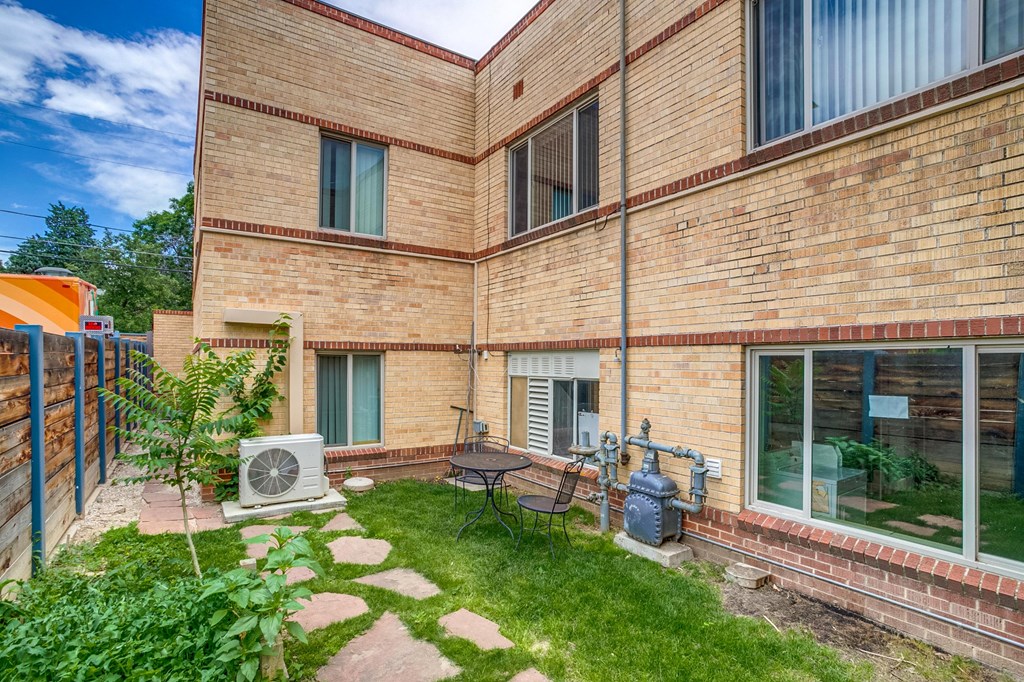 A brick building with a small garden in front.