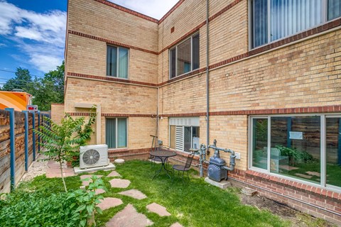 A brick building with a small garden in front.