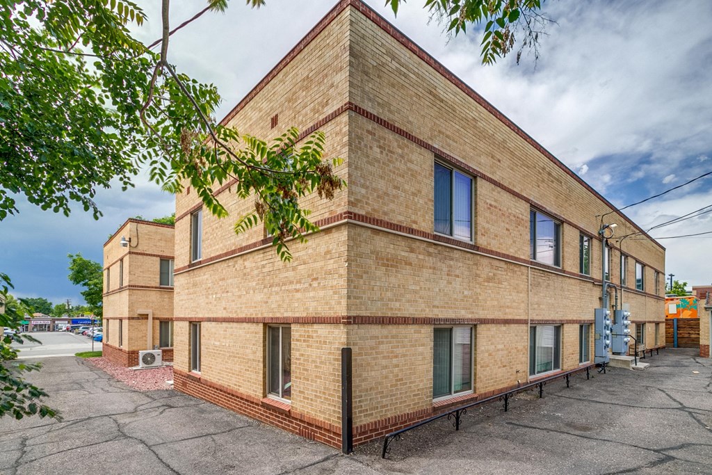 A large brick building with a parking lot in front.