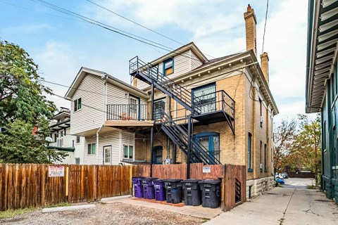A two-story house with a black metal staircase on the side.