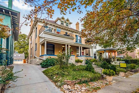 A house with a blue door and a porch with a yellow chair.