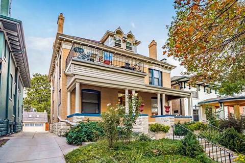 A Victorian style house with a balcony and a blue door.