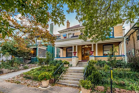 A house with a green front porch and a black railing.