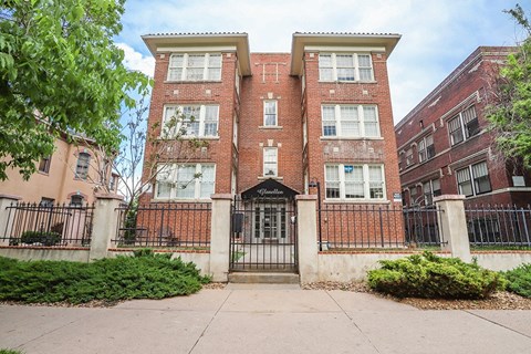 a large brick building with a sidewalk in front of it