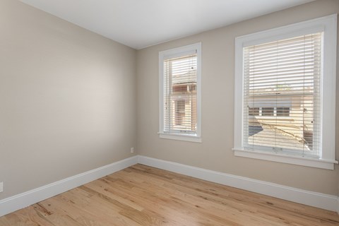 A room with a window and a wooden floor.