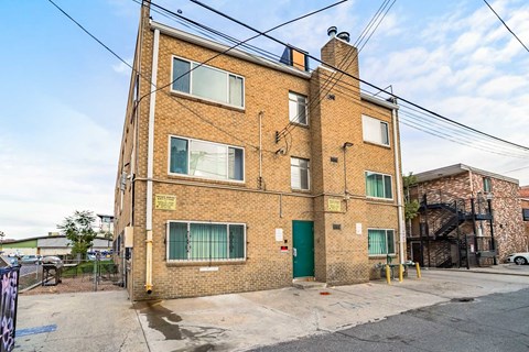 A brick building with a green door and windows.
