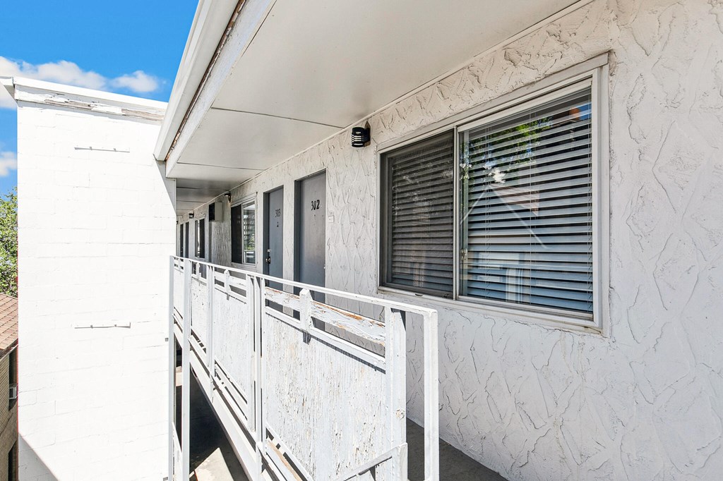 A white building with a balcony and a window.