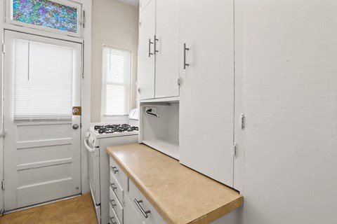 a kitchen with white cabinets and a white door