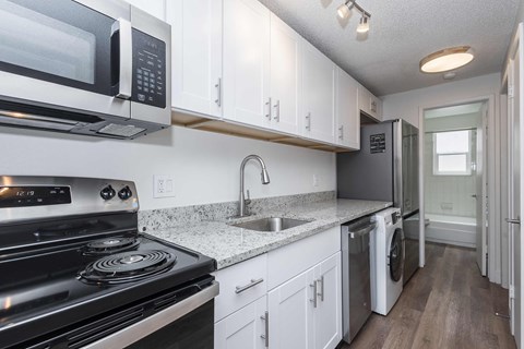 A kitchen with white cabinets and a black stove top oven.