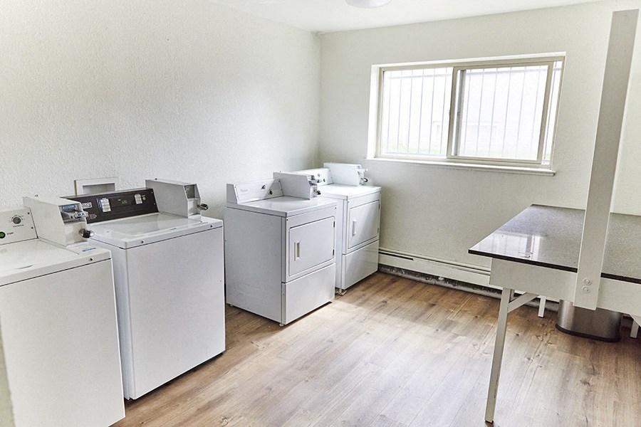 an empty room with washing machines and a table