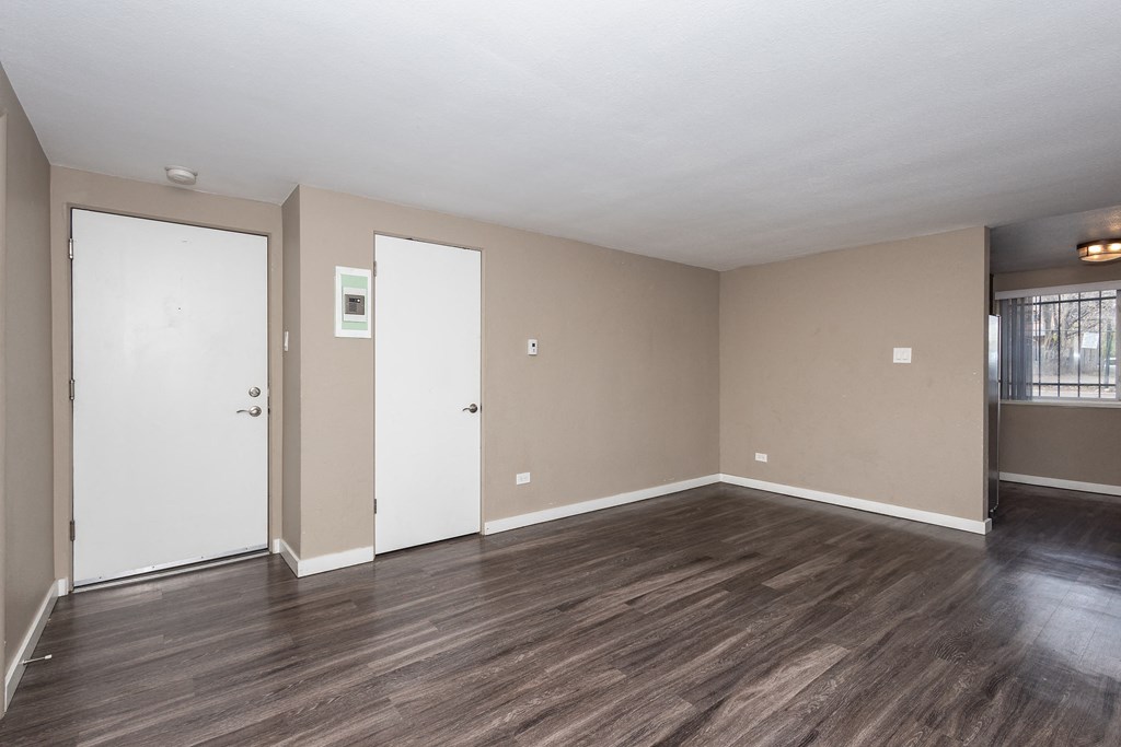 A room with wooden floors and white doors.