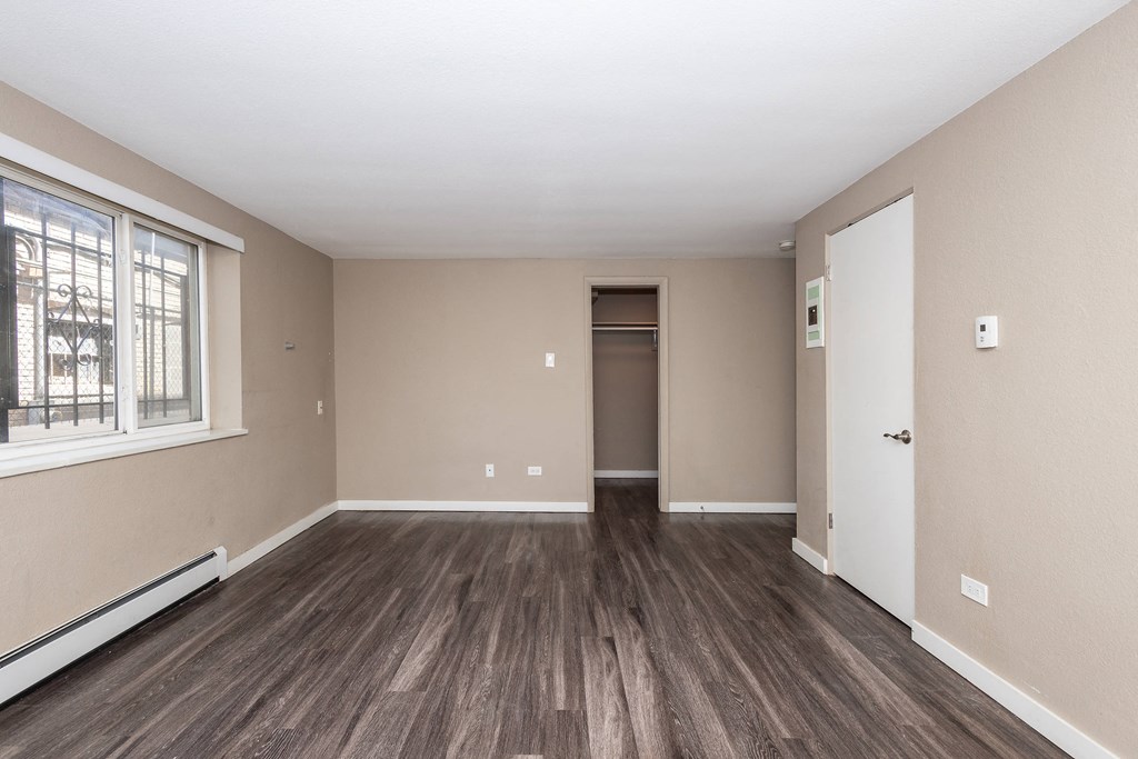 A room with wooden flooring and a white door.