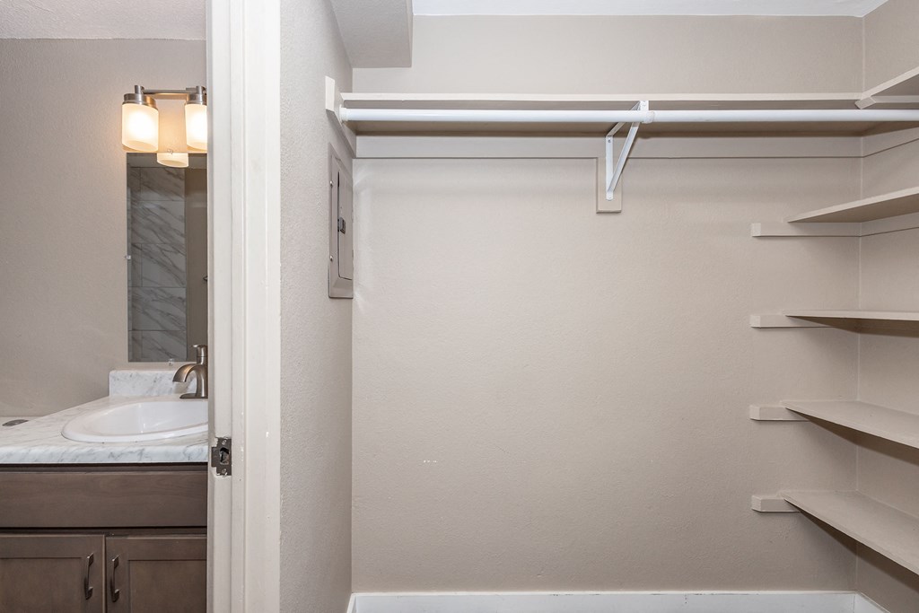 A white bathroom with a sink and a mirror.