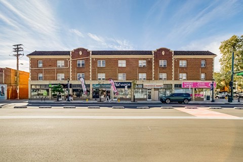 A street view of a building with a car parked in front of it.