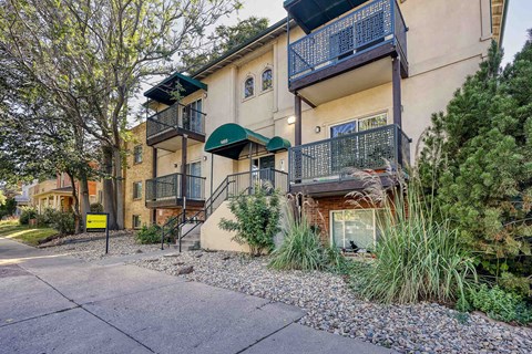 Apartment building with a balcony and a green awning.