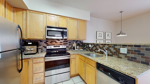 A kitchen with wooden cabinets and a black refrigerator.
