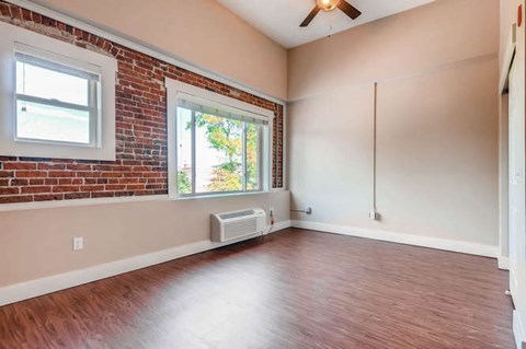 A room with a brick wall and a window.