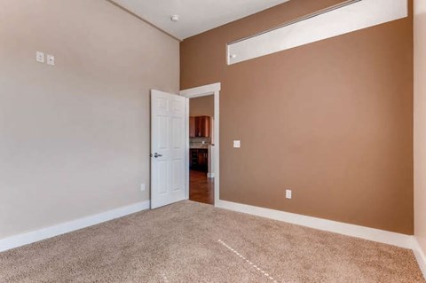 A room with a carpeted floor and a white door.