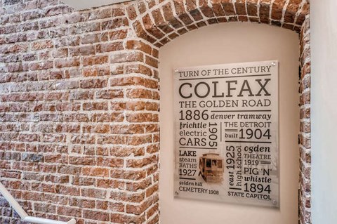 A sign on a brick wall lists the history of the Golden Road.