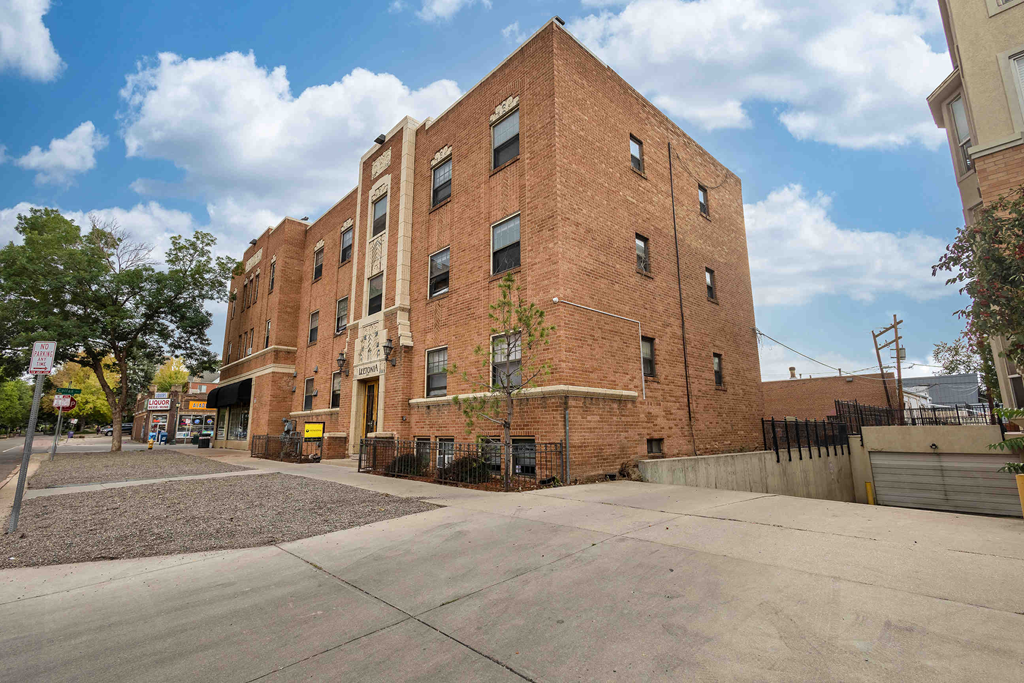 a brick building with a sidewalk in front of it