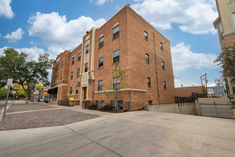 a brick building with a sidewalk in front of it