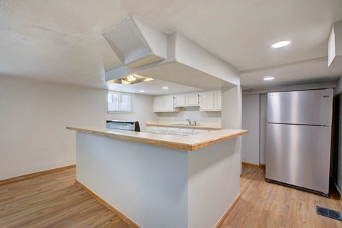 A kitchen with a stainless steel refrigerator and wooden countertops.