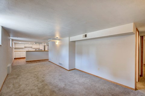 A large empty room with carpeted floor and white walls.