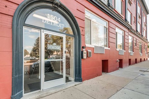A red building with a glass door and the number 1504 Detroit on it.