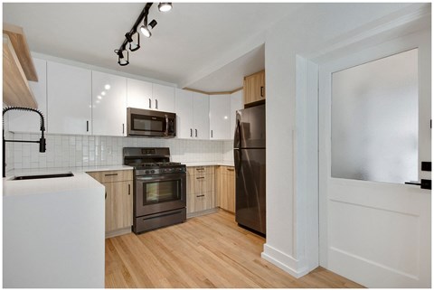 a kitchen with white cabinets and stainless steel appliances