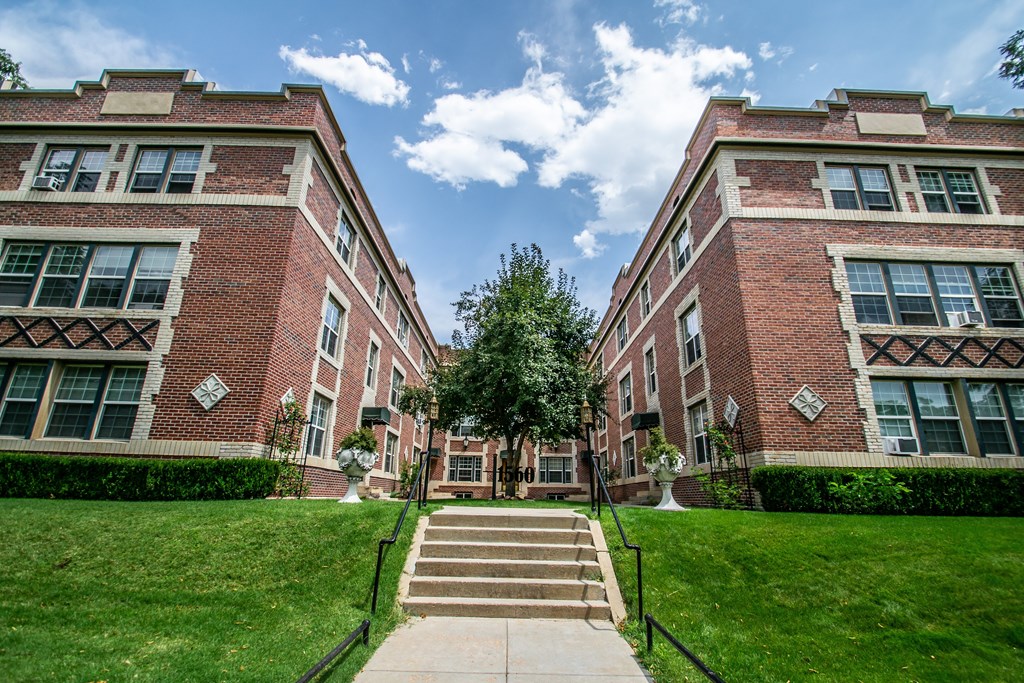 A large brick building with a staircase leading to the entrance.