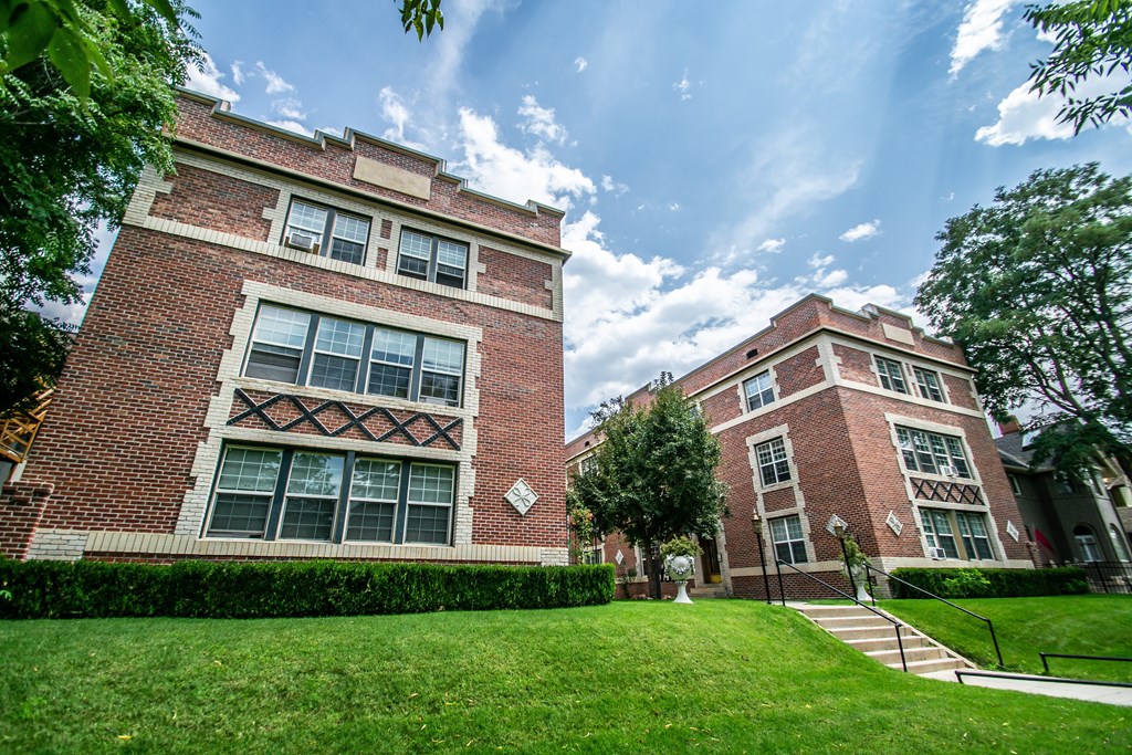 A red brick building with a large window and a cross design on the window.