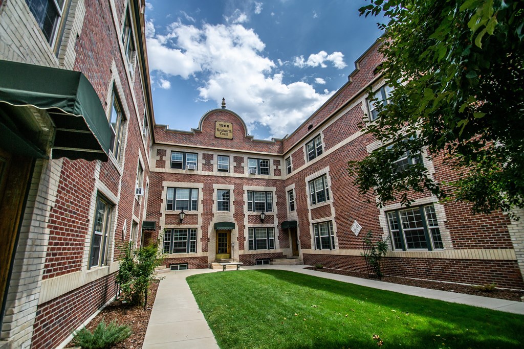 A brick building with a green lawn in front.