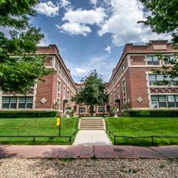 A brick building with a green lawn in front.