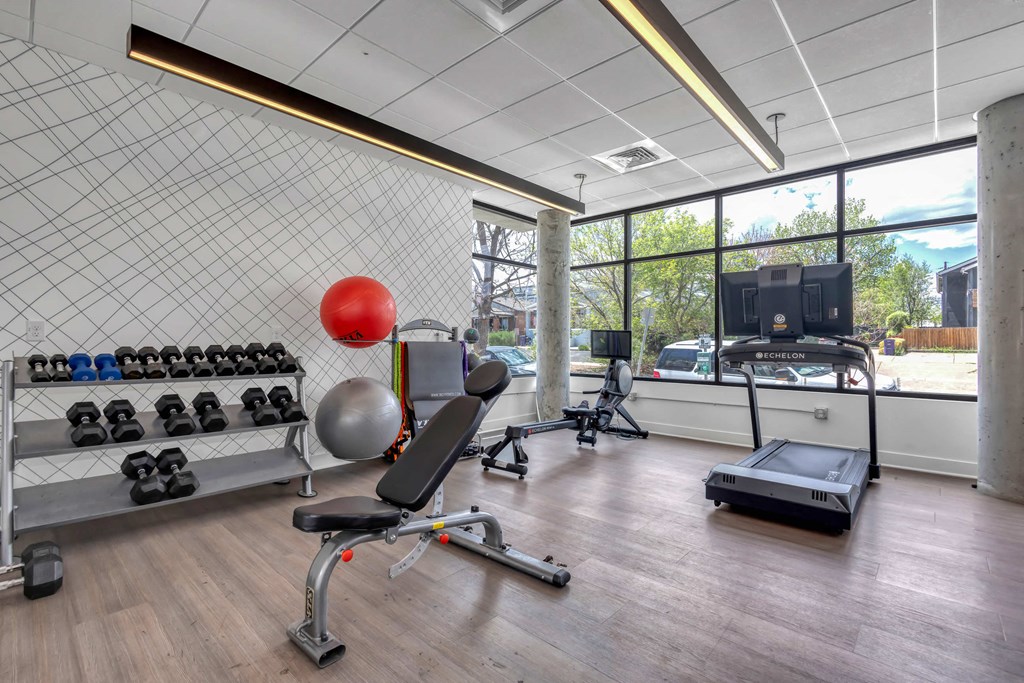 a workout room with a treadmill and weights