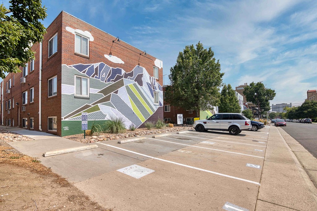 a mural on the side of a building in a parking lot