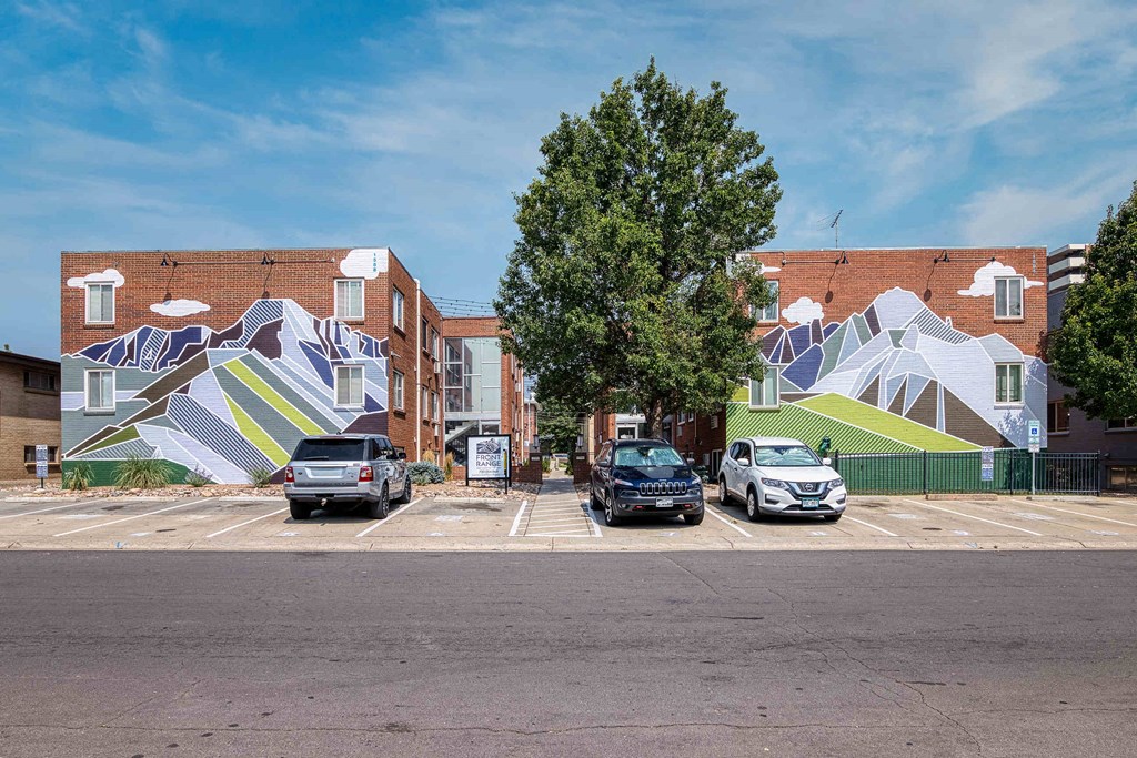 a mural on the side of a building in a parking lot