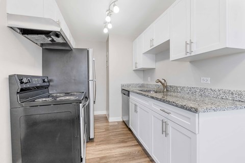 a kitchen with white cabinets and a stainless steel stove and refrigerator