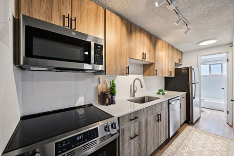 A modern kitchen with a black stove top oven and a black microwave above it.