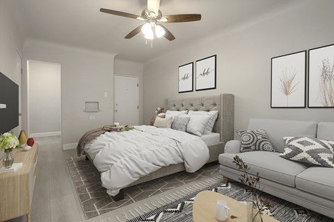 A bedroom with a large bed, a couch, and a ceiling fan.