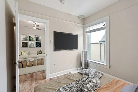 a bedroom with a bed and a tv on the wall