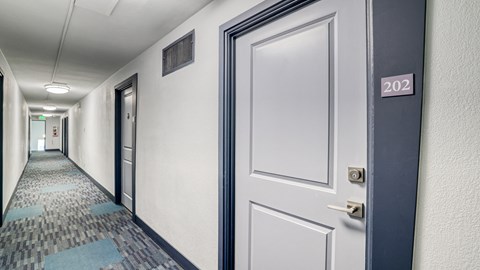 a hallway with white doors and a door number on a door