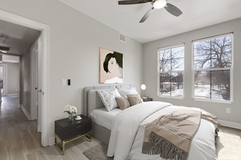 a bedroom with a large white bed and a ceiling fan