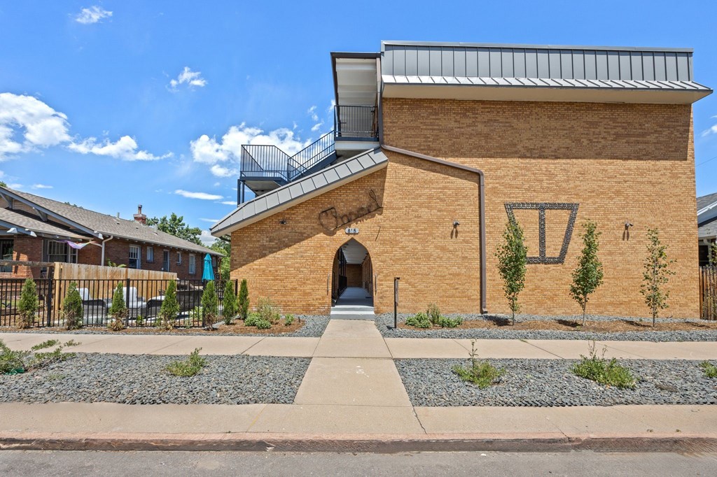 A brick house with a triangular window and a balcony.