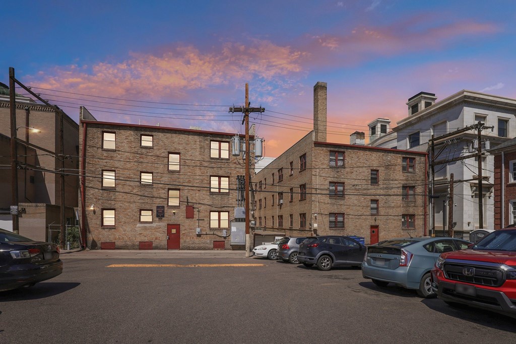 A parking lot with cars and a building in the background.