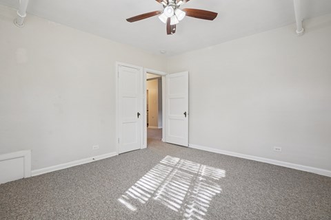 A room with a ceiling fan and a carpet with the letters IBM spelled out on it.