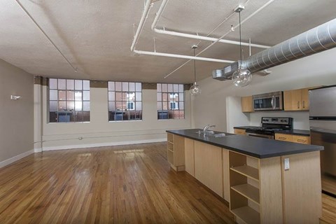 A kitchen with wooden floors and a black countertop.