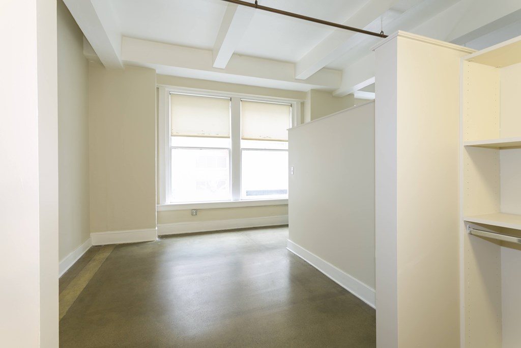A room with a window and a wooden floor.