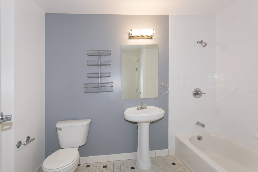 A white toilet sits next to a white pedestal sink in a bathroom.